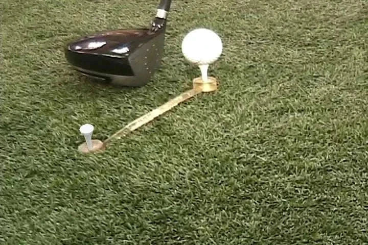 NeverLostGolf Tee Saver ™ on grass with golf ball and driver.