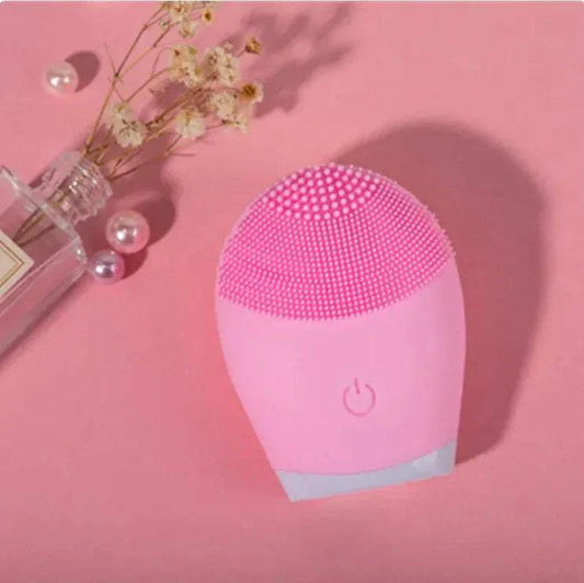 Pink ultrasonic silicone facial cleansing brush on pink background.